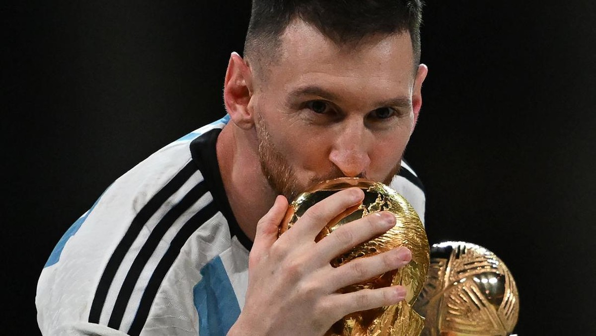 Foto: Kapten dan penyerang Argentina #10 Lionel Messi mencium Trofi Piala Dunia FIFA selama upacara trofi setelah Argentina memenangkan pertandingan sepak bola final Piala Dunia Qatar 2022 antara Argentina dan Prancis di Stadion Lusail di Lusail, utara Doha, Qatar, Minggu (18/12/2022). Argentina menjadi juara Piala Dunia 2022 setelah menang adu penalti atas Prancis 4-2. (Photo by PAUL ELLIS/AFP via Getty Images)