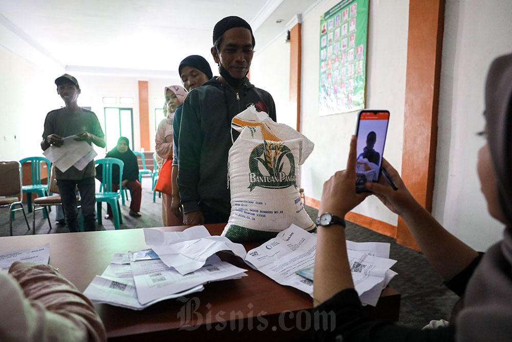 Petugas melakukan verifikasi data penerima bansos saat penyaluran bantuan pangan beras di Desa Sukaharja, Ciomas, Kabupaten Bogor, Jawa Barat. Bisnis/Arief Hermawan P
