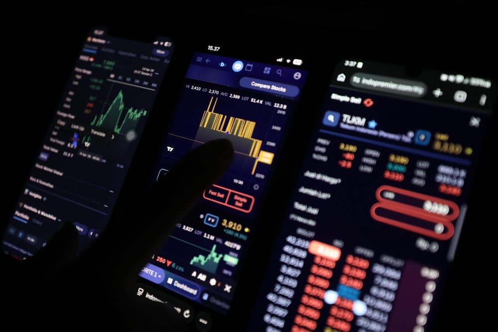 Investor mengamati data saham menggunakan gawai di Jakarta, Selasa (14/4/2026). Bisnis/Himawan L. Nugraha