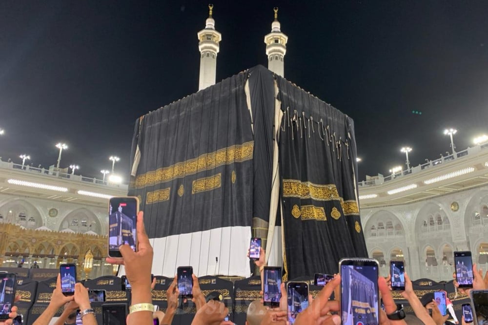Penggantian kiswah atau kain penutup Ka’bah di Masjidilharam, Makkah pada Senin (15/6/2026) malam hingga Selasa (16/6/2026) dini hari waktu Arab Saudi, atau saat memasuki 1 Muharam 1448 H. Kain kiswah lama yang belum diganti di sisi kiri, kain kiswah baru yang sedang diangkat di sisi kanan. / Bisnis–Wibi Pangestu Pratama