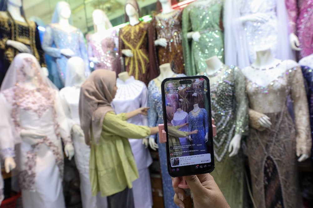 Pedagang menjual produk pakaian secara siaran langsung (live) melalui fitur Shop Tokopedia di aplikasi TikTok di Jakarta, Senin (11/5/2026)./Bisnis-Himawan L. Nugraha