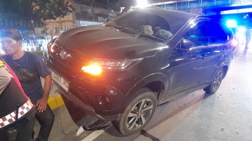 Minibus Hitam Tersangkut di Pembatas Jalan Transjakarta Kawasan Pasar Senen