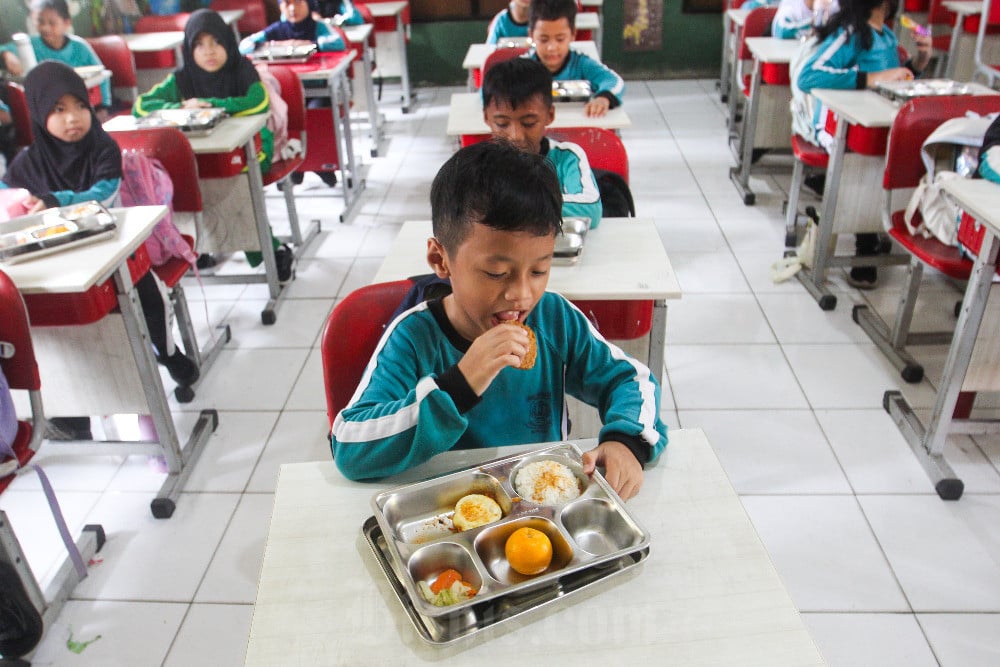 Siswa menyantap makan bergizi gratis (MBG) di SD Negeri Jatiasih 10, Bekasi, Jawa Barat pada Rabu (1/4/2026). / Bisnis-Robby Fathan