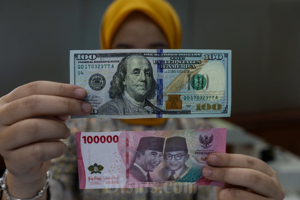 Karyawan menunjukan uang dolar AS di Jakarta, Senin (14/7/2025). Bisnis/Abdurachman