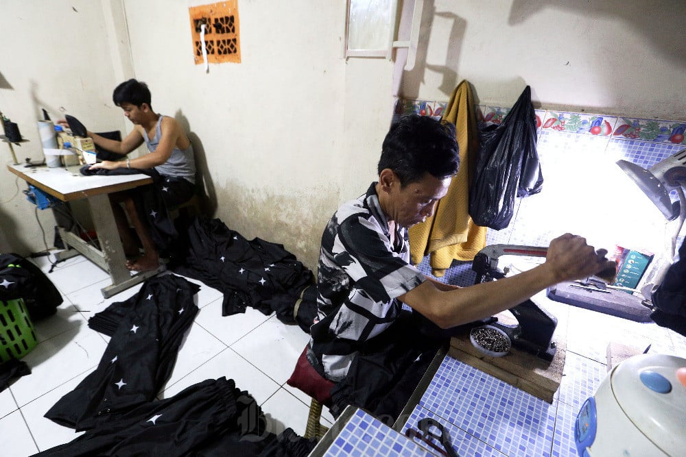 Pakerja menyelesaikan pembuatan produk konveksi di salah satu rumah industri di Cicalengka, Kabupaten Bandung, Jawa Barat, Senin (10/3/2025). Bisnis/Rachman