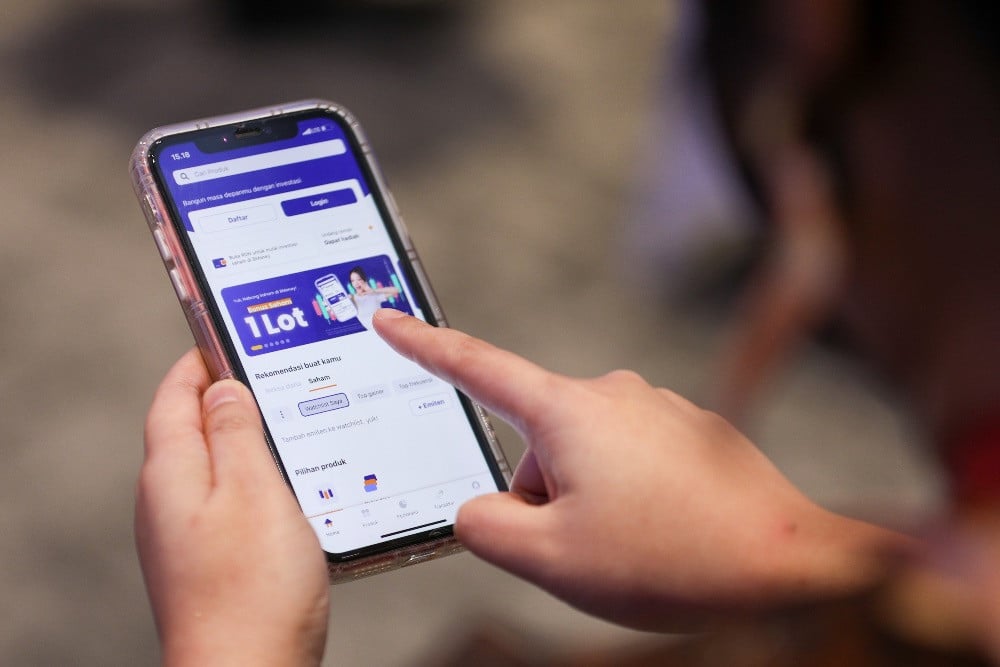 Model menunjukkan aplikasi BMoney dalam acara peluncuran BMoney Saham dan BMoney Privilege di Jakarta, Selasa (16/5). / JIBI/Bisnis/Suselo Jati
