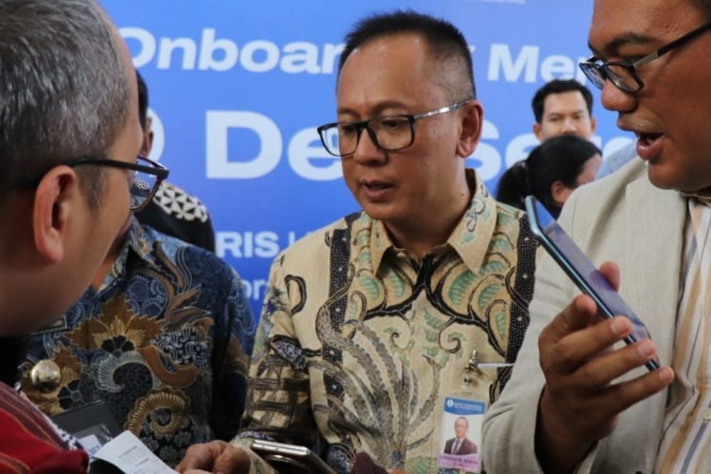 Kepala Perwakilan BI Sumut Ameriza M Moesa bersama Bupati Deli Serdang Asri Ludin Tambunan (kanan) mengikuti simulasi transaksi dengan memindai kode QR pada QRESTO yang disediakan RM Pondok Rame Deli Serdang, Jumat (26/6/2026)./ Bisnis - Delfi Rismayeti
