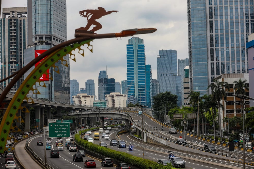 Kendaraan melintas dengan latar belakang jajaran gedung bertingkat di Jakarta, Sabtu (1/3/2025). Pemerintah meyakini pertumbuhan ekonomi pada kuartal I/2025 akan mencapai 5%, terutama didorong oleh momen Ramadan dan Lebaran. / Bisnis-Abdurachman