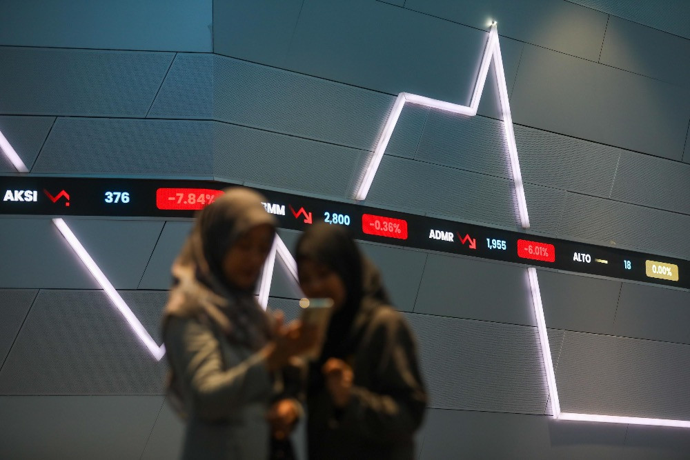 Pegawai mengamati pergerakan harga saham di galeri BEI, Jakarta, Kamis (29/1/2026)./Bisnis/Himawan L. Nugraha