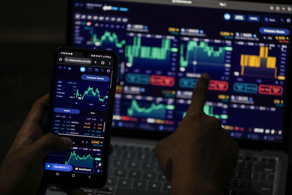 Investor mengamati data saham menggunakan gawai di Jakarta, Senin (29/9/2025)./Bisnis/Himawan L Nugraha