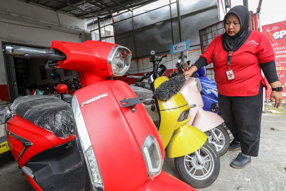 Pekerja membersihkan motor listrik yang dijual di Tangerang Selatan, Banten, Sabtu (9/5/2026). Bisnis/Eusebio Chrysnamurti
