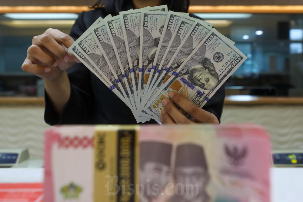 Karyawan menghitung uang dolar AS di salah satu penukaran uang di Jakarta, Selasa (24/6/2025). Bisnis/Abdurachman