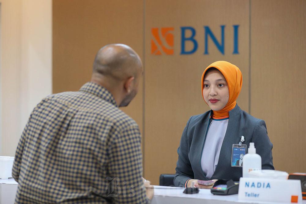 Pegawai melayani nasabah di kantor cabang PT Bank Negara Indonesia (Persero) Tbk. (BBNI). / Bisnis-Himawan L Nugraha
