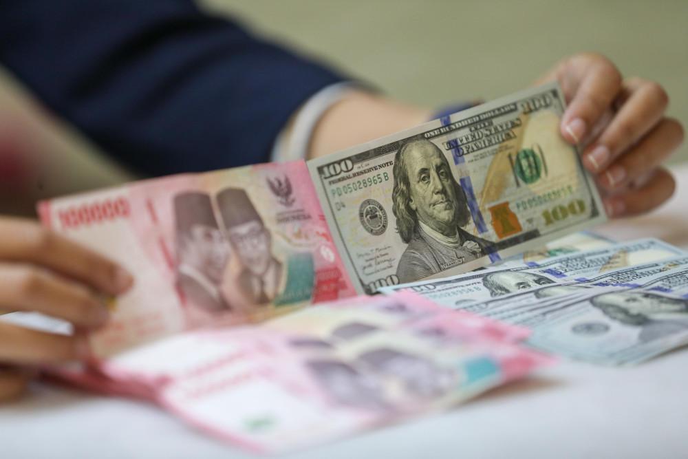 Pegawai menunjukan mata uang dolar Amerika Serikat (AS) dan rupiah di gerai penukaran uang atau money changer Ayu Masagung, Jakarta, Selasa (5/5/2026). Bisnis/Himawan L. Nugraha