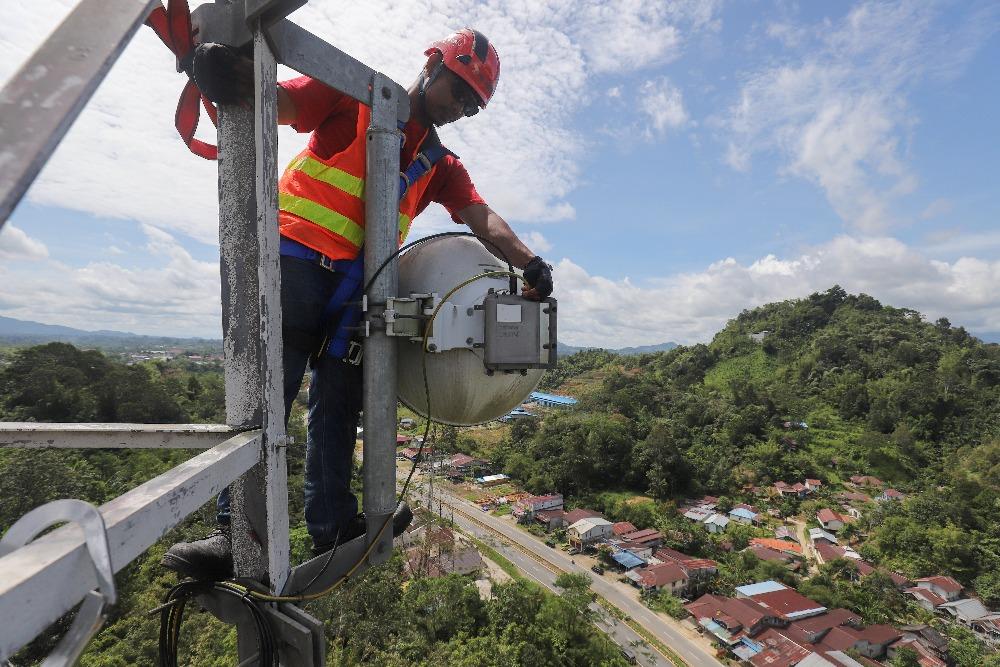 Teknisi melakukan pemeliharaan perangkat BTS di Kecamatan Entikong, Kabupaten Sanggau, Kalimantan Barat, Kamis (9/2/2023)/JIBI/Bisnis/Eusebio Chrysnamurti