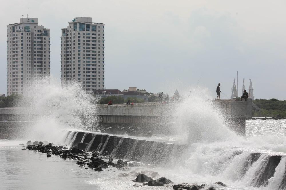 Warga memancing saat ombak besar di kawasan pelabuhan Muara Baru, Jakarta, Senin (2/1)./Bisnis-Himawan L Nugraha