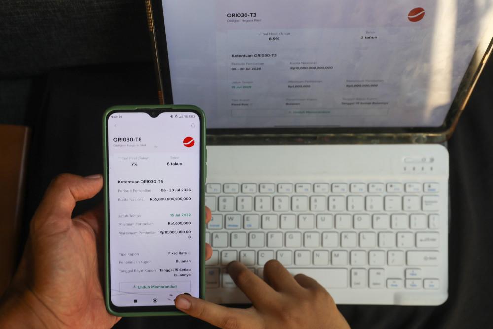 Warga memantau Obligasi Negara Ritel (ORI) di aplikasi investasi digital di Kabupaten Bogor, Jawa Barat, Minggu (5/7/2026). Bisnis/Abdurachman