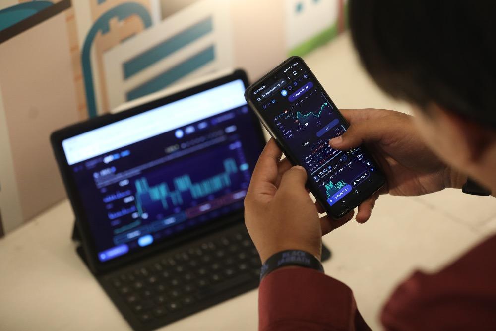 Investor mengamati harga saham menggunakan gawai di Jakarta, Selasa (3/3/2026)./Bisnis/Himawan L. Nugraha